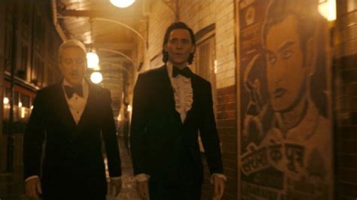 Loki and Mobius pass by a poster featuring Kingo from 'Eternals' in 'Loki' season 2 episode 2.